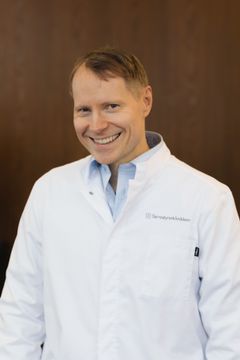 Øyelegen står i hvit frakk