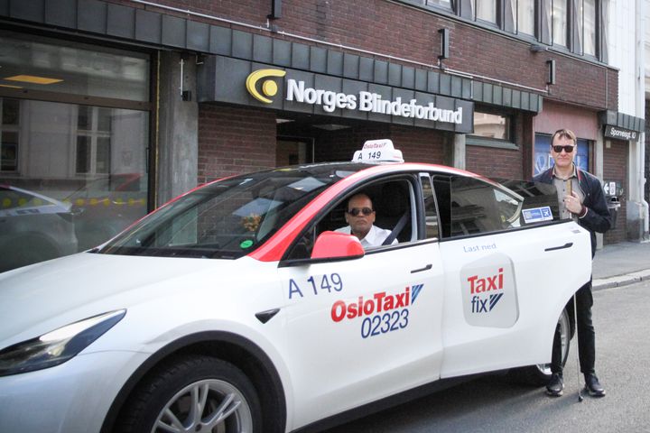 Per Inge Bjerknes ved drosje. Han har hvit stokk og mørke briller.