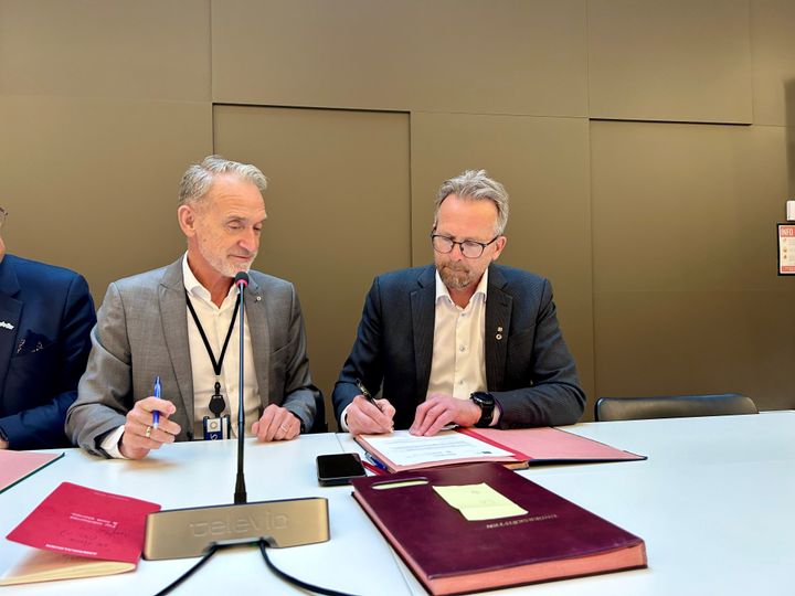 Leder av Unio kommune Geir Røsvoll (th.) signerer avtalen med arbeidslivsdirektør Tor Arne Gangsø