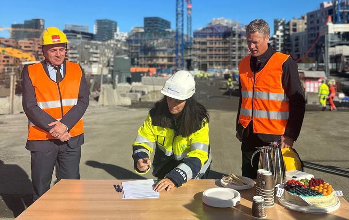 Nina Solli signerer på vegne av byggenæringen, bivånet av Klima- og miljøminister Tore O. Sandvik og Fellesforbundets forbundssekretær Christian Justnes.