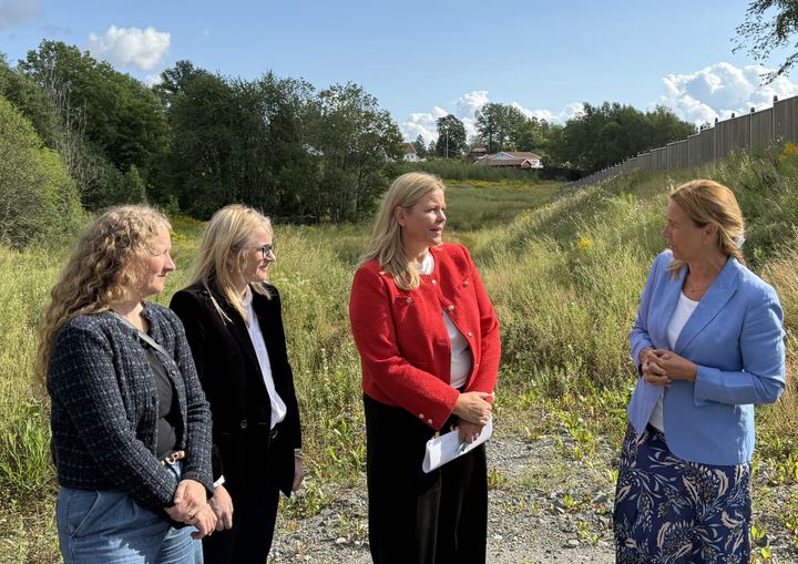 F.v. Leder for Finanskomiteen Tuva Moflag, direktør for samfunnspolitikk i NHO Byggenæringen Guro Hauge, Kommunalminister Kjersti Stenseng og adm. direktør i JM Hilde Vatne på jordet i Folabruveien i Asker, hvor JM venter på å få ferdigregulert området for storstilt boligbygging.