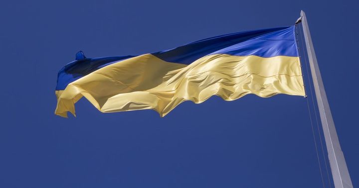 Bilde av det ukrainske flagget som vaier i vinden mot en blå himmel.