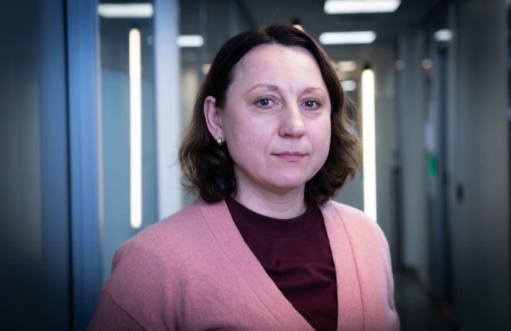 Kvinne i rosa cardigan som ser i kamera.