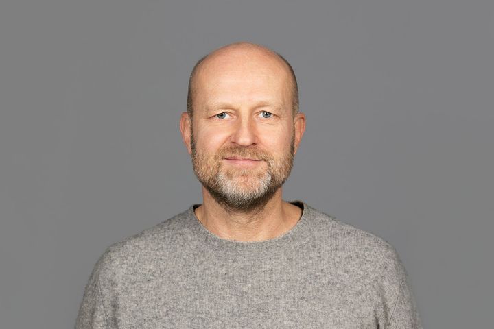 Portrett%20av%20Petter%20Bae%20Brandtz%E6g%20i%20en%20gr%E5%20genser%20mot%20en%20gr%E5%20bakgrunn.