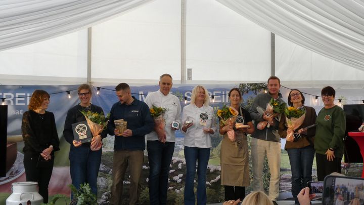 Fem personer mottar Spesialitet-pris på Matstreif, poserer med blomster og produkter.