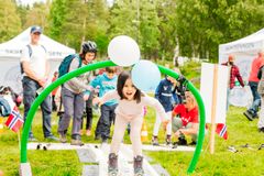 Ei jente på ski bøyer seg under en bue med ballonger i et "skispor" laget av Skiforeningen.