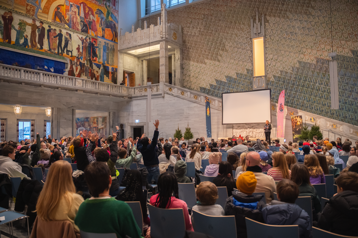 Arrangementet i Oslo rådhus bød på sang og dans, boller og juice, samt fanfare og utdeling av pins fra Hans Majestet Kongens Garde.