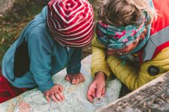 Barn står lent over et kart med kompass i hånda