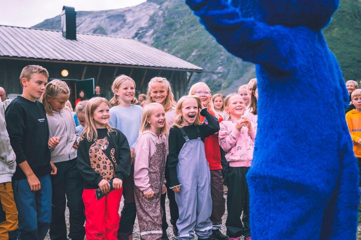 en gruppe barn danser sammen med DNT-maskoten Turbo